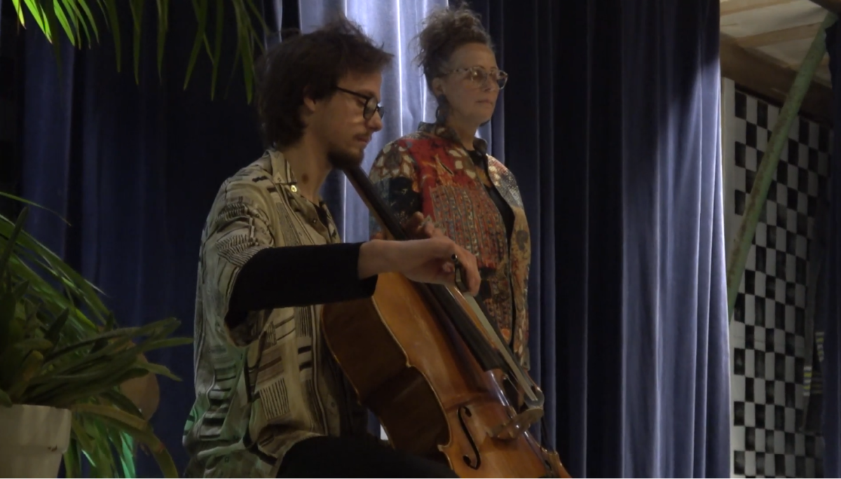 Johannes playing cello while Tet is doing a welcome speech